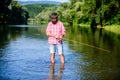 Mature bearded man with fish on rod. big game fishing. relax on nature. successful fisherman in lake water. hipster Royalty Free Stock Photo