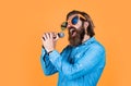 mature bearded man in funny party glasses sing song. brutal male hipster with microphone. vocal school. favorite music Royalty Free Stock Photo