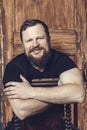 Mature bearded man sitting on vintage door background