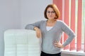 Mature beautiful business woman near office leather white armchair Royalty Free Stock Photo