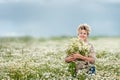 Mature beautiful woman with a bouquet of wild flowers on a mown wheat field. Active recreation, perfect maturity.