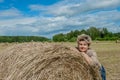 Mature beautiful woman with a bouquet of wild flowers on a mown wheat field. Active recreation, perfect maturity