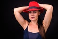 Mature beautiful woman wearing red fedora hat against black background Royalty Free Stock Photo