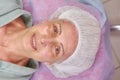 Mature beauty clinic patient smiling.