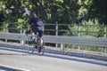 Mature biker crossing river bridge on local road