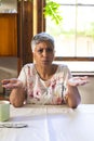 A mature biracial woman looks confused at home on a video call Royalty Free Stock Photo