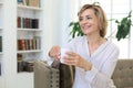 Mature blond woman in couch having a tea or coffee Royalty Free Stock Photo