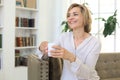 Mature blond woman in couch having a tea or coffee Royalty Free Stock Photo