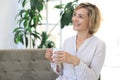 Mature blond woman in couch having a tea or coffee Royalty Free Stock Photo