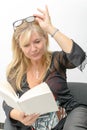 Mature blond woman reading a book Royalty Free Stock Photo