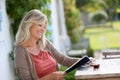 Mature blond woman reading and drinking coffee Royalty Free Stock Photo