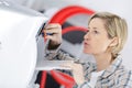 Mature blond woman repairing ventilation