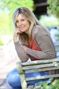 Mature blond woman sitting in garden Royalty Free Stock Photo