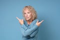 Mature blonde woman pointing to both sides with fingers in different direction Royalty Free Stock Photo