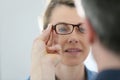 Mature blong woman trying on glasses