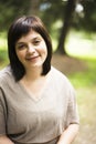 Mature brunette fat woman in green garden, smiling, friendly wel Royalty Free Stock Photo