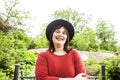 Mature brunette woman in green garden wearing hat, smiling Royalty Free Stock Photo