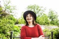 mature brunette woman in green garden wearing hat, smiling, frie Royalty Free Stock Photo