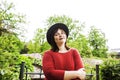 mature brunette woman in green garden wearing hat, smiling, frie Royalty Free Stock Photo