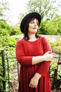 mature brunette woman in green garden wearing hat, smiling, frie Royalty Free Stock Photo