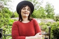 Mature brunette woman in green garden wearing hat, smiling, friendly welkoming, lifestyle people concept close up Royalty Free Stock Photo