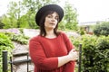 Mature brunette woman in green garden wearing hat, smiling, friendly welkoming, lifestyle people concept close up Royalty Free Stock Photo