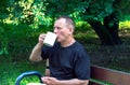 Mature brutal muscular man aged 55-60 sitting in a green garden Royalty Free Stock Photo