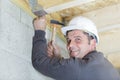 mature builder using hammer on roof joist