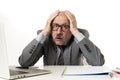 Mature business man with bald head on his 60s working stressed and frustrated at office computer laptop desk looking desperate