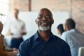 Mature business man sitting in a meeting, conference or seminar in a boardroom with colleagues at work. Closeup portrait Royalty Free Stock Photo