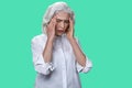 Mature business woman suffering from migraine on color background. Royalty Free Stock Photo