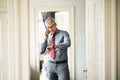 Mature businessman on a business trip standing in a hotel room, making phone call. Royalty Free Stock Photo