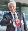 Mature businessman checking time on his watch after checked in at airport Royalty Free Stock Photo