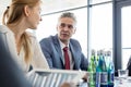 Mature businessman discussing with female colleague in board room Royalty Free Stock Photo