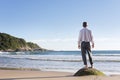 Mature businessman enjoying the beach while standing alone on a rock Royalty Free Stock Photo