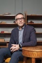 Mature businessman with grey hair in suit and glasses sitting by the table in office, looking to th camera Royalty Free Stock Photo