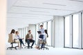 Mature businessman having discussion with team on chair in new office Royalty Free Stock Photo