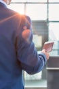 Rear view of mature businessman holding his passport and boarding pass at airport Royalty Free Stock Photo