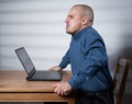 Mature businessman with laptop at his desk, hostile attitude