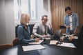 Mature businessman laughing during an office meeting with collea