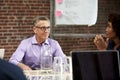 Mature Businessman Leading Office Meeting Of Colleagues Sitting Around Table Royalty Free Stock Photo