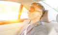 Photo of Mature businessman napping while wearing eye mask in car with yellow lens flare in background Royalty Free Stock Photo