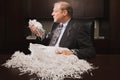 Mature businessman playing with paper shreddings Royalty Free Stock Photo