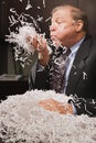 Mature businessman playing with paper shreddings Royalty Free Stock Photo