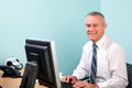 Mature businessman sat at his office desk