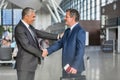 Mature businessman shaking hands with business partner in airport Royalty Free Stock Photo