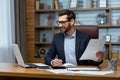 Mature businessman in shirt doing paperwork, man working with documents, contracts and bills sitting at table using Royalty Free Stock Photo