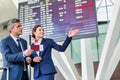 Mature businessman showing his boarding pass with the attractive airport staff Royalty Free Stock Photo