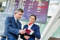 Mature businessman showing his boarding pass with the attractive airport staff Royalty Free Stock Photo