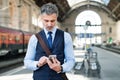 Mature businessman with smartphone on a train station. Royalty Free Stock Photo